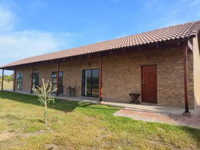a small brick house with a grass yard at Olyfburg Herberg in Tierpoort