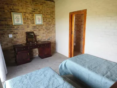 a bedroom with a bed and a table with a mirror at Olyfburg Herberg in Tierpoort