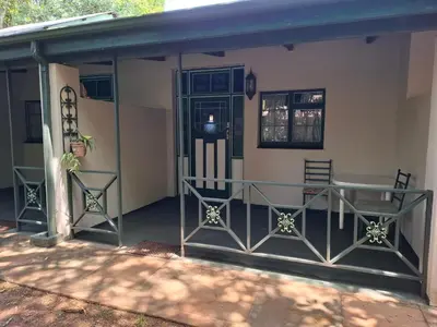 a screened in porch with two chairs and a table at Plaas Klein Paradys in Blydebos