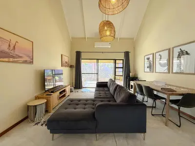 a living room with a couch and a table at Plumtree House in Hoedspruit