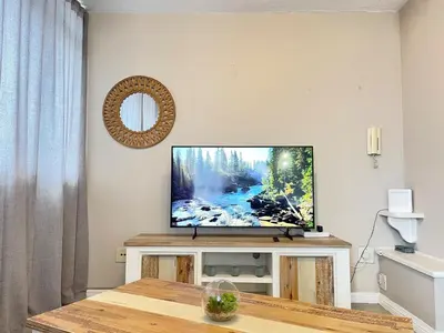 a flat screen tv sitting on a wall in a living room at Menlyn Place 203 in Pretoria