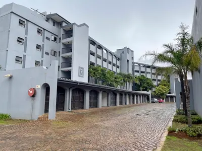 a large white building with a palm tree in front of it at Menlyn Place 203 in Pretoria
