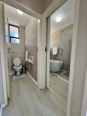 a bathroom with a tub and a toilet and a sink at Menlyn Place 203 in Pretoria