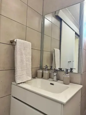 a bathroom with a white sink and a mirror at Menlyn Place 203 in Pretoria