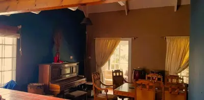 a room with a table and chairs and a blue wall at The Dutch House in Dullstroom