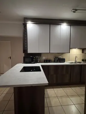a kitchen with white cabinets and a counter top at Luxe Haven in Nelspruit
