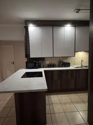 a kitchen with white cabinets and a counter top at Luxe Haven in Nelspruit