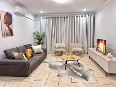 a living room with a couch and a table at Luxe Haven in Nelspruit