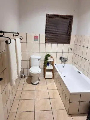 a bathroom with a toilet and a bath tub at Luxe Haven in Nelspruit