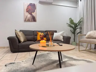 a living room with a couch and a table with a candle at Luxe Haven in Nelspruit