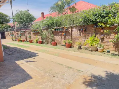 a brick wall with a bunch of potted plants on it at Urban Oasis Guest House in Pretoria