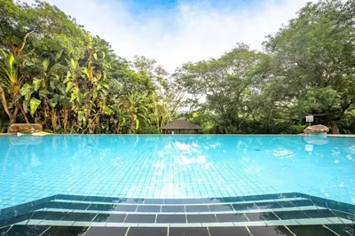 a swimming pool with trees in the background at First Group Sanbonani Resort in Hazyview