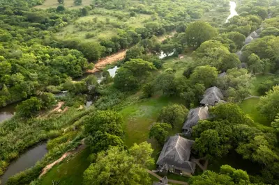 an aerial view of a forest withvillages and a river at First Group Sanbonani Resort in Hazyview