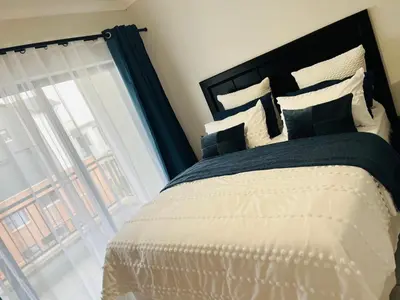 a bedroom with a large bed and a window at The Blyde in Pretoria