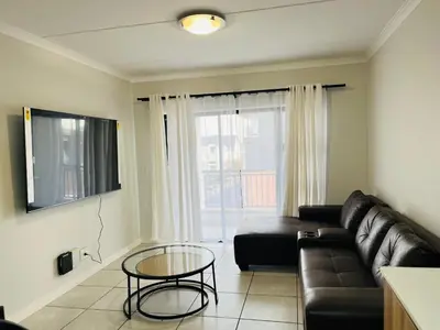 a living room with a couch and a glass table at The Blyde in Pretoria