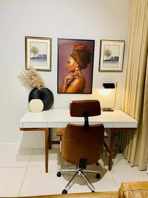 a desk with a chair and a painting on a wall at KMaya at Ellipse Waterfall in Midrand