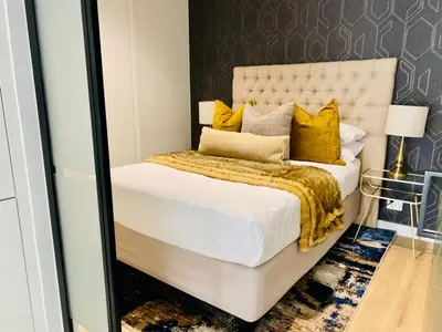 a bedroom with a large white bed with yellow pillows at KMaya at Ellipse Waterfall in Midrand