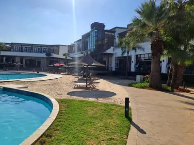 a resort with a swimming pool and palm trees at The Blyde Tranquil Mint Resort Pretoria in Pretoria