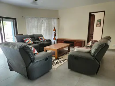 a living room with two couches and a table at Villa in the Wild in Marloth Park