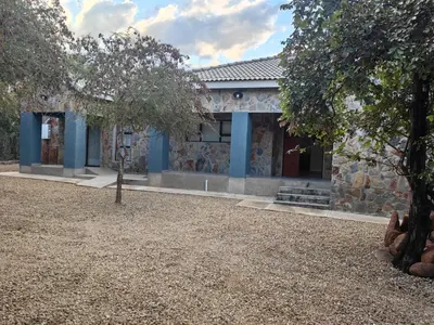 a stone building with a tree in front of it at Villa in the Wild in Marloth Park