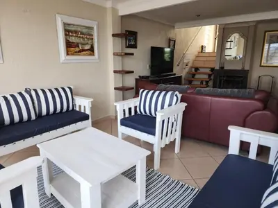 a living room with white furniture and a couch at BondMakers Hidden Gem in Hartbeespoort