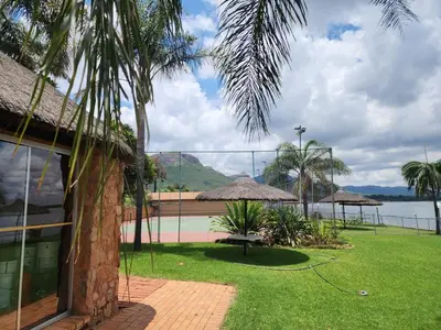 a house with a grass yard with a hose at BondMakers Hidden Gem in Hartbeespoort