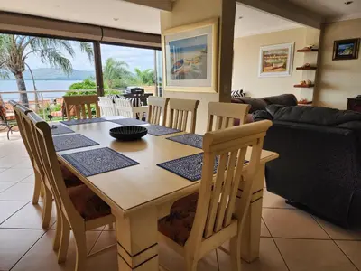 a dining room table and chairs with a view of the ocean at BondMakers Hidden Gem in Hartbeespoort