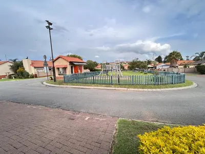 an empty street with a blue fence and a playground at 3 Bed Holiday Home in Witbank