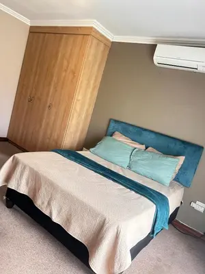 a bed with a blue headboard in a room at 3 Bed Holiday Home in Witbank
