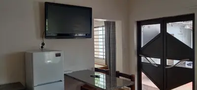 a room with a refrigerator and a tv on the wall at Shalom Cottage in Kempton Park