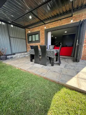 a patio with chairs and a table in a backyard at Hannie Pot in Pretoria