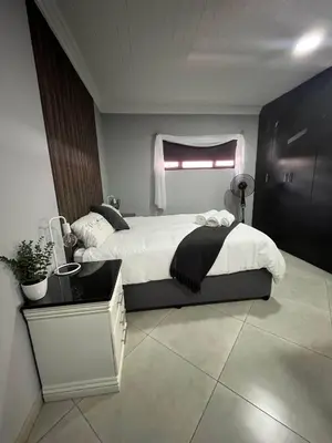 a bedroom with a large bed and a window at Hannie Pot in Pretoria