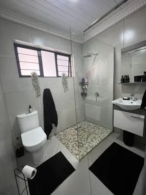 a bathroom with a shower and a toilet and a sink at Hannie Pot in Pretoria