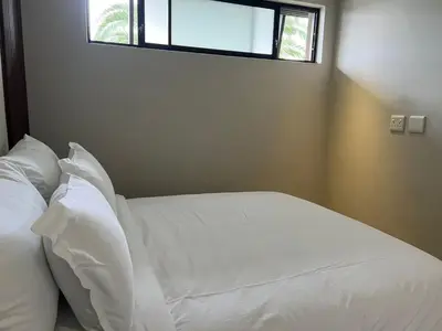 a white bed with white pillows and a window at 15 On Slice in Polokwane