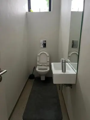 a bathroom with a toilet and a sink and a mirror at 15 On Slice in Polokwane