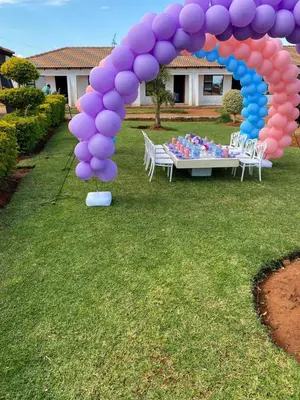 a purple and blue arch with a table with balloons at Marula Tree Lodge in Moletlane