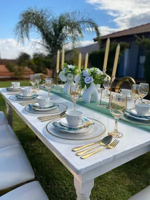 a white table with plates and wine glasses on it at Marula Tree Lodge in Moletlane