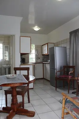 a kitchen with a table and a refrigerator at Angel Cottage in Tzaneen