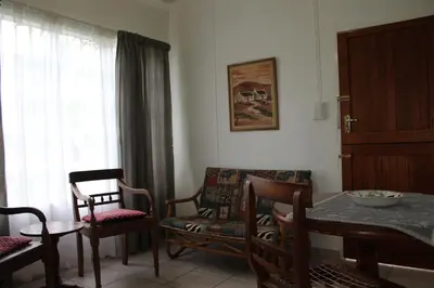 a living room with a table and chairs and a window at Angel Cottage in Tzaneen