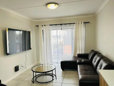 a living room with a couch and a glass table at The Blyde in Pretoria