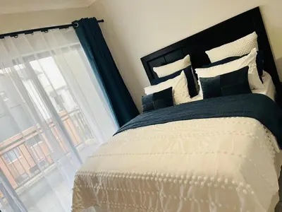 a bedroom with a large bed and a window at The Blyde in Pretoria