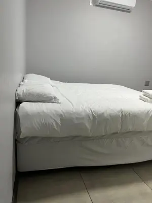 a white bed in a white room with a white wall at Skylabs Housing in Polokwane