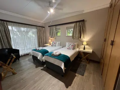 a bedroom with two beds and a window at Doornboom Guesthouse in Pretoria