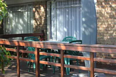 a row of chairs and tables on a deck at Doornboom Guesthouse in Pretoria