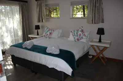 a bedroom with a bed with two shoes on it at Doornboom Guesthouse in Pretoria
