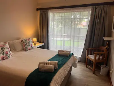 a bedroom with a bed with two towels on it at Doornboom Guesthouse in Pretoria