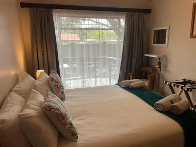 a bedroom with a large bed with pillows and a window at Doornboom Guesthouse in Pretoria