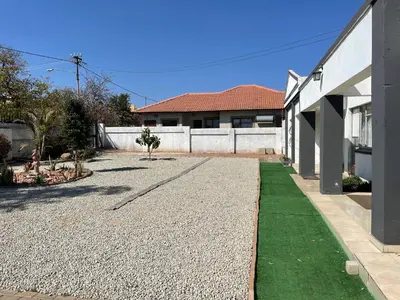 a house with a gravel driveway in front of a house at Northgatelodges and Tours in Polokwane