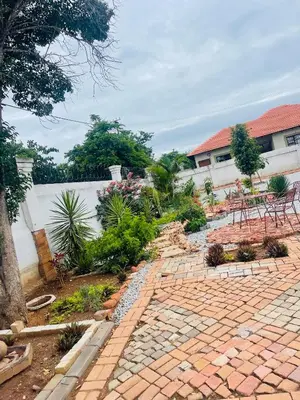 a garden with a brick walkway in front of a building at Northgatelodges and Tours in Polokwane