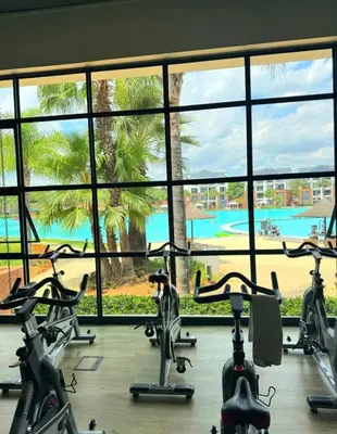 a gym with exercise bikes in front of a large window at The blyde apartment in Pretoria